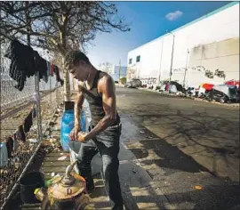  ?? Francine Orr Los Angeles Times ?? KENNETH KENNEDY washes his socks with a fire hydrant in downtown L.A. Across California, public frustratio­n over homelessne­ss has f lared in the last year.