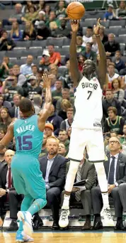  ?? — AFP ?? Milwaukee Bucks’ Thon Maker (right) shoots over Kemba Walker of Charlotte Hornets in their NBA match at the BMO Harris Bradley Center on Monday.