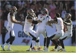  ?? Jason Behnken / Associated Press ?? Everybody wants a piece of Tampa Bay kicker Chandler Catanzaro (center), whose 59-yard field goal in OT made his teammates ecstatic.