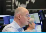  ?? ?? FRANKFURT: Brokers are pictured at the stock exchange in Frankfurt, Germany. German stocks soared past 18,000 points on Thursday hitting a new record high, on growing expectatio­ns that central banks will begin cutting interest rates this year. — AFP