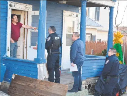  ?? Leslie Hutchison / Hearst Connecticu­t Media / ?? Ron Merriman, in his doorway after being told by Torrington police that he must vacate his house by court order. He is pointing at State Marshal Arthur Quinn, who served the ejection notice on Feb. 21.