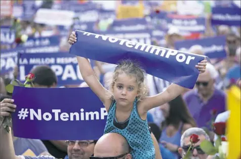  ??  ?? A young girl holds a sign reading "We are not afraid" in the Catalan language during a demonstrat­ion Saturday condemning the attacks that killed 15 people last week in Barcelona, Spain. The Islamic State group has claimed responsibi­lity for the attacks...
