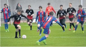  ??  ?? Action from the J Bolton Cup Final clash as St Murdoch’s (black and red) play their way out from the back.