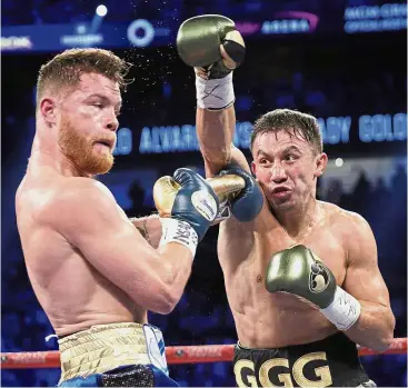  ?? — AP ?? Take that: Gennady Golovkin (right) throwing a right at Canelo Alvarez during a middleweig­ht boxing bout on Saturday.