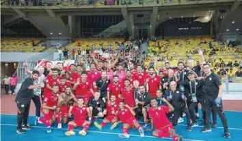  ?? ?? Oman players and coaching staff celebrate their win in Kuala Lumpur.