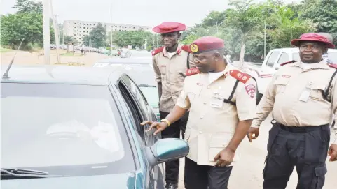  ?? IKECHUKWU IBE ?? Zonal Commanding Officer FRSC Abuja, Jonas Agwu, questions a motorist near NNPC Mega Filling Station, during a special patrol by FRSC to remove vehicular obstructio­ns at filling stations in the FCT yesterday.
