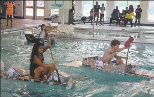  ??  ?? From left, Henry Lackey High School students Francesca Rothell, Mariel Santos and D.J. Nelson take part in a recycled boat race held in the swimming pool Monday.