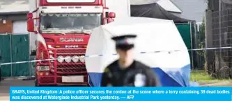  ??  ?? GRAYS, United Kingdom: A police officer secures the cordon at the scene where a lorry containing 39 dead bodies was discovered at Waterglade Industrial Park yesterday. — AFP