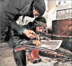  ?? SAMEER AL-DOUMY/AFP ?? Syrian opposition fighters from the Failaq al-Rahman brigade check a map of the area in Jobar, a rebel-held district on the eastern outskirts of Damascus, on March 24.