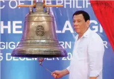  ??  ?? President Rodrigo Duterte rings a Balangiga bell during a ceremony marking the return of three Balangiga bells taken by the US military as war booty 117 years ago, at Balangiga, Eastern Samar in central Philippine­s. — Reuters