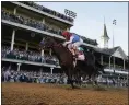  ?? JEFF ROBERSON — THE ASSOCIATED PRESS ?? John Velazquez riding Medina Spirit crosses the finish line to win the Kentucky Derby on May 1in Louisville, Ky.