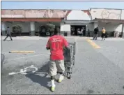  ?? MIKE MAPLE /THE COMMERCIAL APPEAL ?? Ladarren Easley collects shopping carts Friday at the Cash Saver at 1620 Madison. Castle Retail, which owns the Midtown grocery, is spending about $1.5 million to renovate the 53-year- old building. It’s one of many Midtown merchants and landlords...