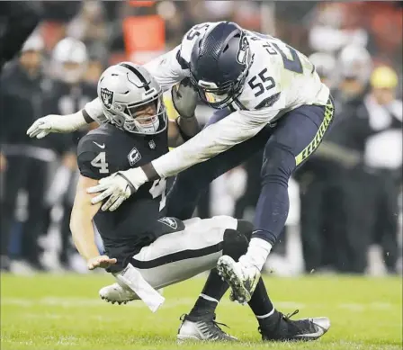  ?? Associated Press ?? Seattle’s Frank Clark sacks Oakland quarterbac­k Derek Carr in a game in London earlier this month.