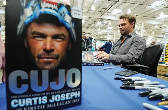  ?? LARRY WONG ?? Ex-NHL goalie Curtis Joseph, seen at a signing event in Edmonton for his new book Cujo, tackles his difficult childhood, among other topics, with writer Kirstie McLellan Day.