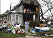  ?? TIMOTHY D. EASLEY — THE ASSOCIATED PRESS ?? Brittany Oakley checks in with relatives Friday outside of what is left of her home in Lakeview, Ohio.