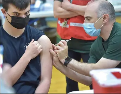  ?? PETE BANNAN - MEDIANEWS GROUP ?? Dr. Mark Ciarlone gives 11th-grade student Thomas Kwait the Pfizer COVID vaccine at Ridley High School Monday afternoon.