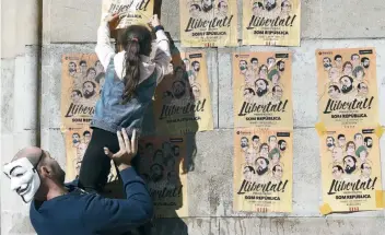  ??  ?? Cientos de personas acudieron ayer a la plaza Universita­t de Barcelona para pegar carteles en la ciudad y el conjunto de Cataluña para pedir la libertad de los ocho ex consejeros encarcelad­os.