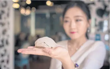  ??  ?? Elaine Zhang, owner of the NestCha restaurant, presents a dried bird’s nest in her restaurant in Shanghai.