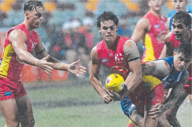  ?? Picture: AAP ?? HARD AT IT: Jack Bowes of the Suns about to fire off a handpass during the Round 1 AFL match against North Melbourne Kangaroos at Cazalys Stadium.