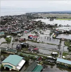  ?? MELCHOR HILOTIN / ASSOCIATED PRESS ?? Floodwater­s caused by Typhoon Vongfong inundate a village in the eastern Philippine­s on Friday.