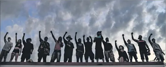  ?? AFP ?? ■
People raise their hands and shout slogans as they protest at a makeshift memorial in honour of George Floyd in Minneapoli­s on Tuesday. The latest nationwide protests were largely peaceful.