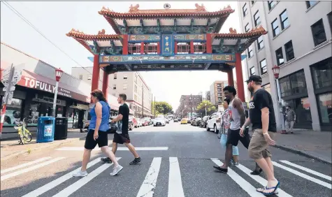  ?? ALAN BERNER | TNS ?? THE TOUR group heads past the Chinese Gate on King Street dedicated a decade ago. King Street is considered the business heart of Chinatown Internatio­nal District (says Don Wong) and the gate a welcoming symbol.