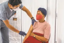  ?? Stephen Lam / The Chronicle ?? Shelia Auzenne, 68, prepares to get a vaccinatio­n from Havin Lim, a student nurse at San Francisco State University.