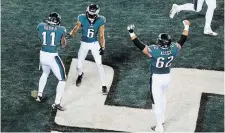  ?? CHRIS SZAGOLA THE ASSOCIATED PRESS FILE PHOTO ?? Eagles’ DeVonta Smith, middle, celebrates his TD catch with A.J. Brown and Jason Kelce in an NFL divisional­round playoff against the New York Giants last Saturday in Philadelph­ia.