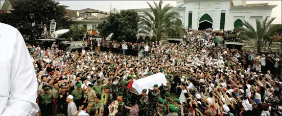  ?? MIFTAHULHA­YAT/JAWA POS ?? KEHILANGAN BESAR: Ribuan orang mengantar jenazah KH Hasyim Muzadi menuju tempat pemakaman di Pondok Pesantren Al Hikam, Depok, kemarin.