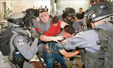  ??  ?? LUCHA. Funcionari­os policiales de Israel forcejean con manifestan­tes palestinos en la Puerta de Damasco, vía de acceso a la Ciudad Vieja.