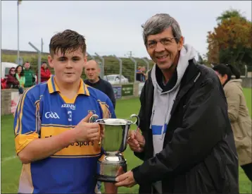  ??  ?? Tomacork’s Cian Moules collects the cup from Mick Murphy.