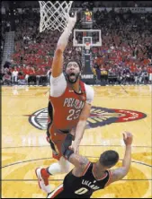  ?? Scott Threlkeld The Associated Press ?? Pelicans forward Anthony Davis soars to the basket over Trail Blazers guard Damian Lillard in the second half of New Orleans’ 131-123 win Saturday at the Smoothie King Center.