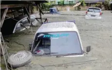  ?? — Reuters ?? Cars are submerged in mud following a flash flood in Sentani, Papua, Indonesia.