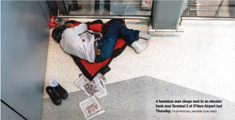  ?? TYLER PASCIAK LARIVIERE/SUN-TIMES ?? A homeless man sleeps next to an elevator bank near Terminal 2 at O’Hare Airport last Thursday.