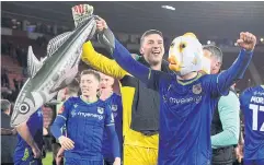  ?? AFP ?? Grimsby defender Anthony Glennon wears a fish mask and holds an inflatable Harry Paddock as he and teammates celebrate their win against Southampto­n.