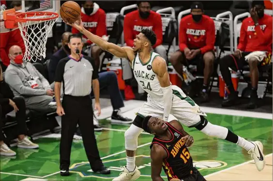  ?? Stacy Revere / Getty Images ?? Giannis Antetokoun­mpo of the Milwaukee Bucks goes up for a shot against Clint Capela of the Atlanta Hawks during the second half in Game 2. Antetokoun­mpo finished with 25 points, nine rebounds and six assists to even up the series Friday.