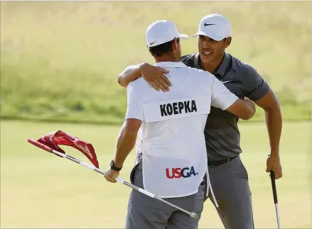  ?? STREETER LECKA / GETTY IMAGES ?? Brooks Koepka celebrates with his caddie, Richard Elliott, on the 18th green Sunday during his U.S. Open victory at Shinnecock Hills Golf Club. Curtis Strange was the last golfer to win two U.S. Opens in a row 29 years ago.