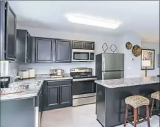  ?? NVR/Ryan Homes ?? Dark-stained cabinets and a large island anchor the kitchen in the Lorien Fields model at the Festival of Homes.