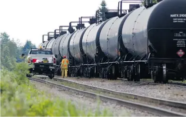  ?? ALLEN MCINNIS/ THE GAZETTE ?? Transport Safety Board inspectors in Nantes on July 17 prepare to draw samples from a fuel tanker car involved in the Montreal, Maine and Atlantic Railway derailment that caused massive damage to the downtown core of Lac-Mégantic. The weakness to...