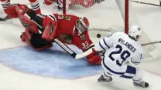  ?? JEFF HAYNES/THE ASSOCIATED PRESS ?? Leafs centre William Nylander gets a puck past Blackhawks goalie Scott Darling during the third period Saturday in Chicago.