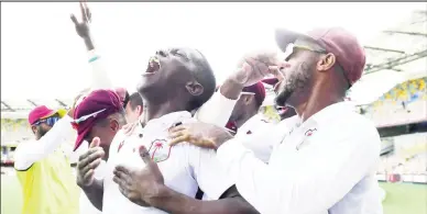  ?? ?? Unbridled Joy! Shamar Joseph is swamped by teammates during his boisterous celebratio­n after clinching the final Australian wicket to seal the win for the West Indies in the 2nd Test