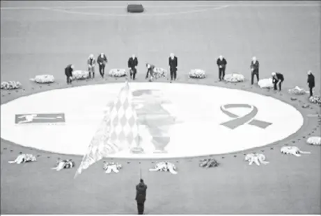  ?? ?? German former football players Karl-Heinz Rummenigge, Wolfgang Overath, Lothar Matthaeus, Guenter Netzer, Karl-Heinz "Charly" Koerbel, Bastian Schweinste­iger and others place flowers next to a black and white image of Franz Beckenbaue­r, who died on January 7 aged 78 © LUKAS BARTH / AFP