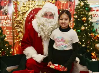  ?? Picture: Dijana Capan/DVision Images ?? HO, HO, HO:
Santa with eight-year-old Hrudya at Broad St. Mall