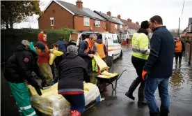  ?? Photograph: Henry Nicholls/Reuters ?? Residents and rescue workers unload sandbags on a flooded street in Bentley near Doncaster on 9 November.