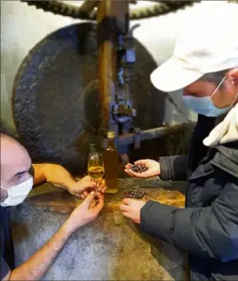  ?? (Photo M. T.) ?? Le moulinier, Olivier Baudoin, et l’oléiculteu­r, Xavier Beauchamp, réunis devant la meule du moulin hydrauliqu­e du village. De l’entretien des olivaies à la production d’huile d’olive, toute la chaîne est ranimée.