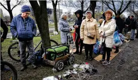  ?? ALEXEI ALEXANDROV / AP ?? Residents gather near a generator to charge mobile devices in an area controlled by Russian-backed separatist forces in Mariupol, Ukraine, on April 22.