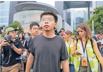  ?? FOTO: DPA ?? Joshua Wong (M), einer der führenden Köpfe der Demokratie­bewegung, nachdem er mit Demonstran­ten gesprochen hat.