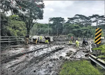  ?? AP ?? Crews clear damage from Hurricane Lane Friday near Hilo, Hawaii, in this photo provided by Jessica Henricks,. Hurricane Lane barreled toward Hawaii on Friday, dumping torrential rain that inundated the Big Island’s main city as people elsewhere stocked up on supplies and piled sandbags.