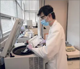  ?? James Estrin / New York Times ?? Alexander Clare, a microbiolo­gist, puts samples into a centrifuge at the Newtown Creek Wastewater Treatment Plant in Brooklyn on Oct. 6.