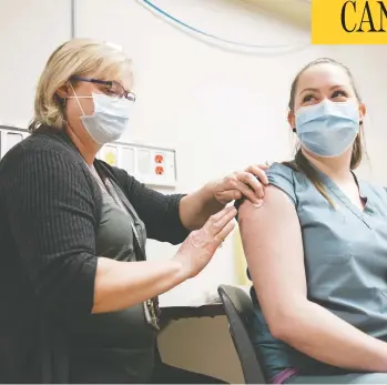  ?? MICHAEL BELL/THE CANADIAN PRESS ?? Registered nurse Debbie Frier, left, injects Leah Sawatsky, an emergency room nurse, with the Pfizer-biontech COVID-19 vaccine at Regina General Hospital on Tuesday.